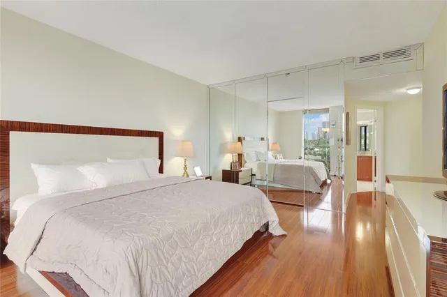 a bedroom with a large bed and a wooden floor