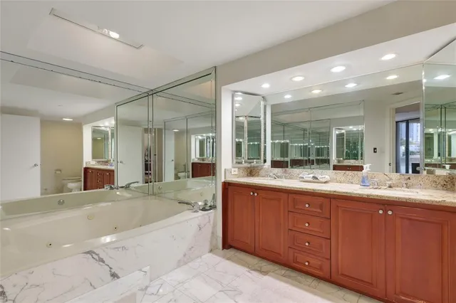 a large bathroom with a large tub vanity sink and mirrors