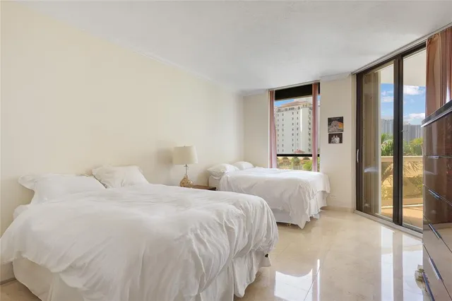 a bedroom with two beds and a large window