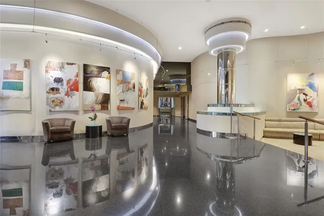 a living room with couches and kitchen view with wooden floor