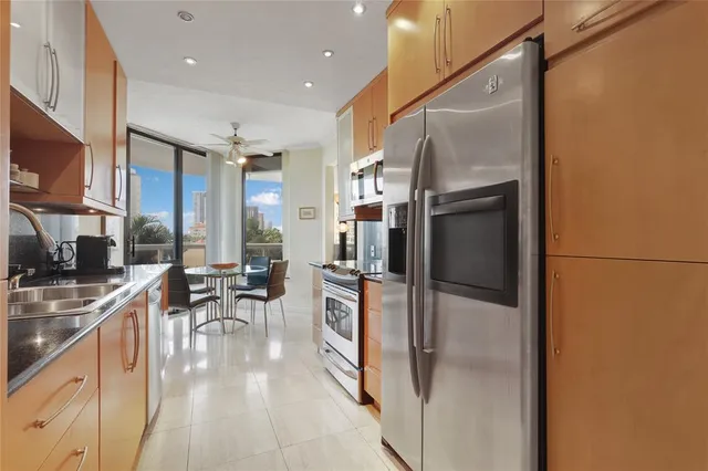 a kitchen with stainless steel appliances granite countertop a refrigerator and a sink