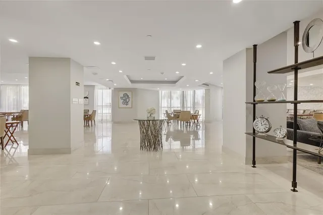 a lobby with furniture and a dining table with kitchen view