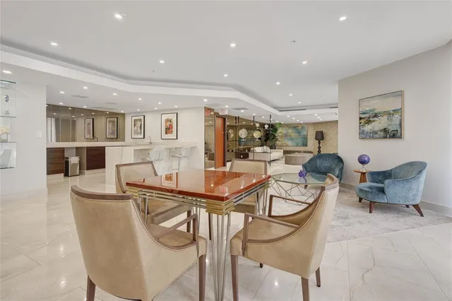 a living room with furniture a table and kitchen view