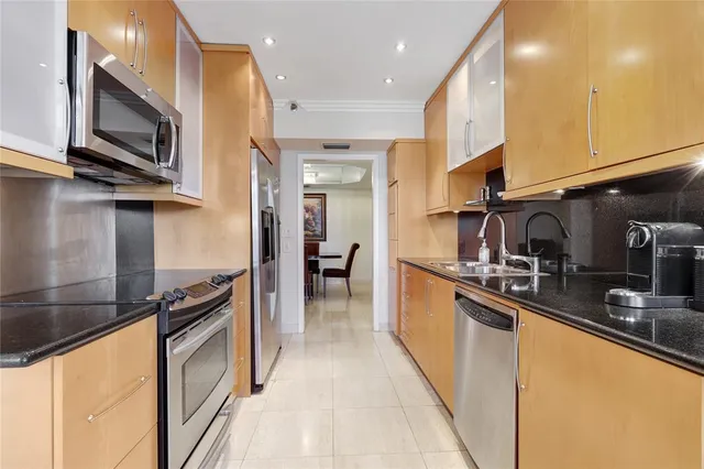 a kitchen with stainless steel appliances granite countertop a refrigerator a sink and a stove