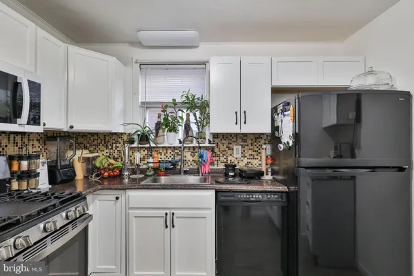 a kitchen with stainless steel appliances granite countertop a refrigerator sink and stove