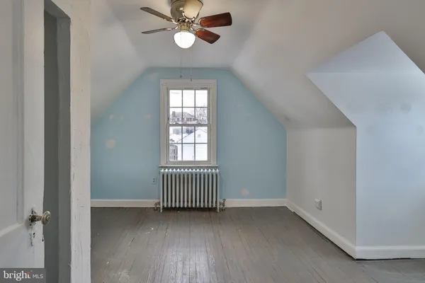 an empty room with a bathroom and a chandelier fan