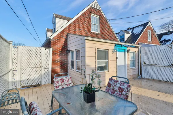 a view of a patio with table and chairs with wooden floor and fence