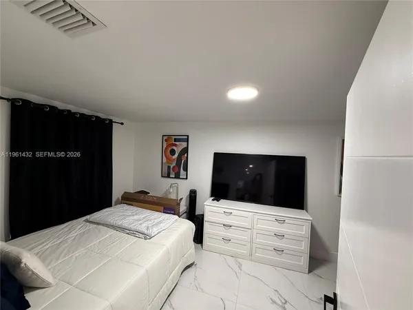 a bedroom with a bed and a flat screen tv