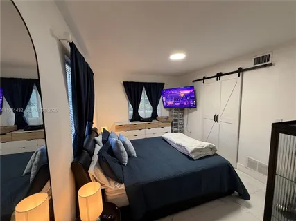 a bedroom with a bed and a flat screen tv