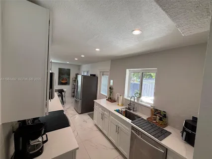 a kitchen with refrigerator and sink