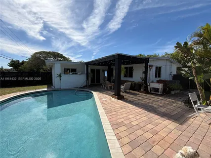 a view of a house with backyard and sitting area