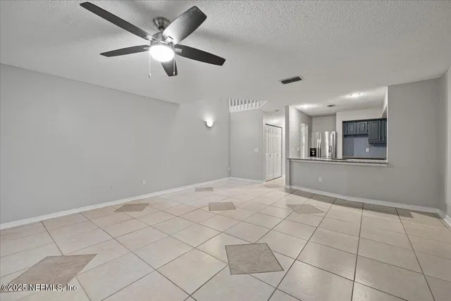a view of an empty room and a ceiling fan
