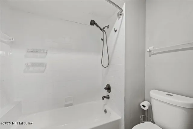 a bathroom with a shower a toilet and a shower