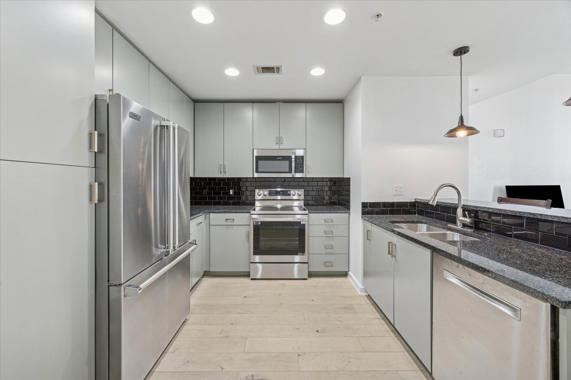 a kitchen with a sink stainless steel appliances and cabinets