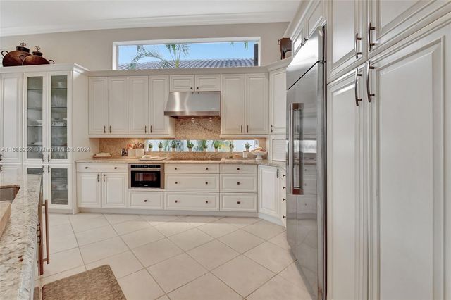 a kitchen with kitchen island granite countertop a sink and cabinets