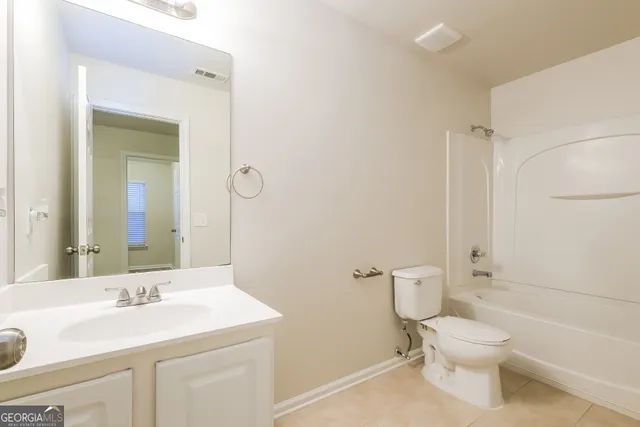 a bathroom with a granite countertop toilet a sink and a mirror