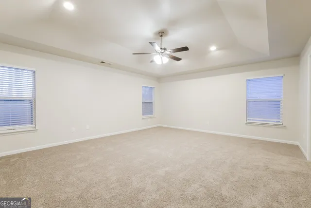 an empty room with a window and a ceiling fan