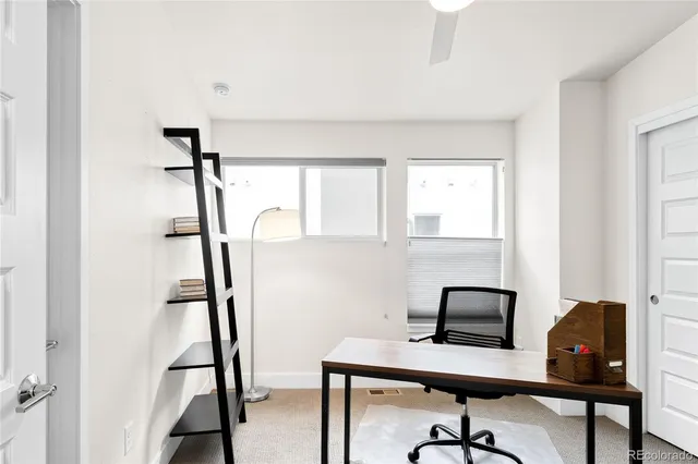 a view of a workspace with furniture and a window