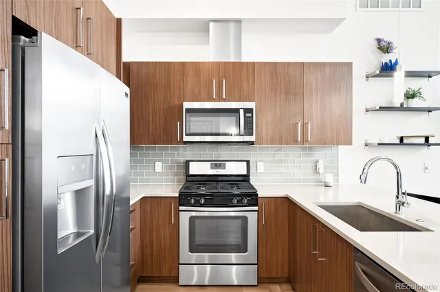 a kitchen with granite countertop a refrigerator stove and microwave