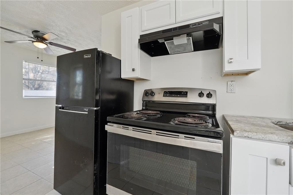 324 Brooks Avenue Southwest, Unit B Atlanta, GA 30310 - Photo 11 of 25 a kitchen with stainless steel appliances white cabinets and a stove top oven