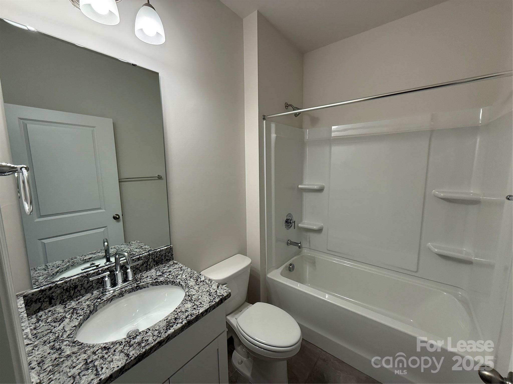 4144 Steel Way Sherrills Ford, NC 28673 - Photo 12 of 24 a bathroom with a granite countertop sink toilet mirror and a bathtub