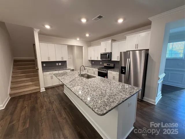 a kitchen with a refrigerator stove and white cabinets