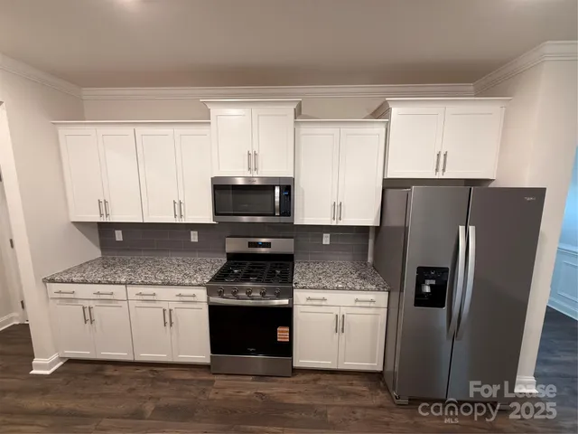 a kitchen with granite countertop stainless steel appliances and wooden cabinets