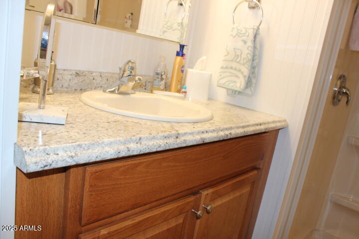 303 South Recker Road, Unit 223 Mesa, AZ 85206 - Photo 15 of 31 a bathroom with a granite countertop sink and a mirror
