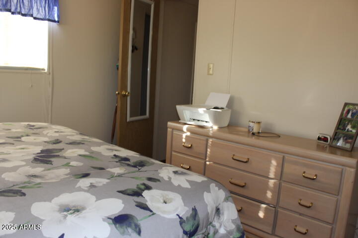 303 South Recker Road, Unit 223 Mesa, AZ 85206 - Photo 18 of 31 a bedroom with a bed and a dresser