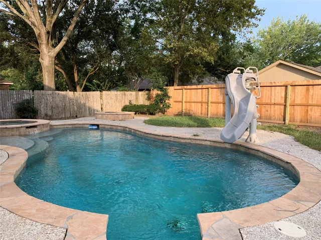 a view of a backyard with swimming pool