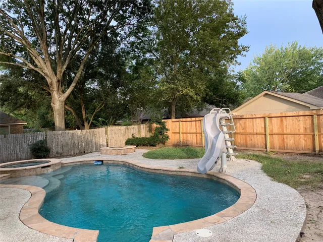 a swimming pool with outdoor seating and yard
