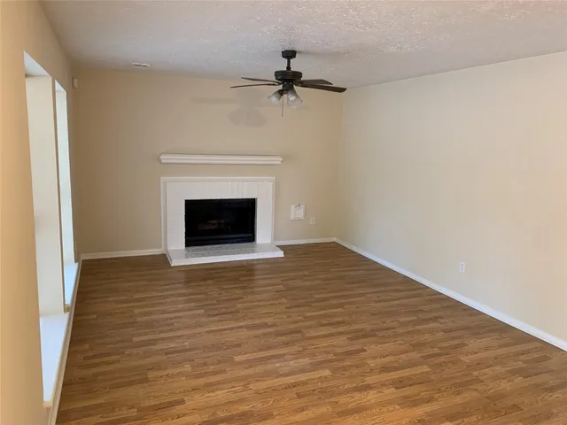 a view of a livingroom with wooden floor and a fireplace