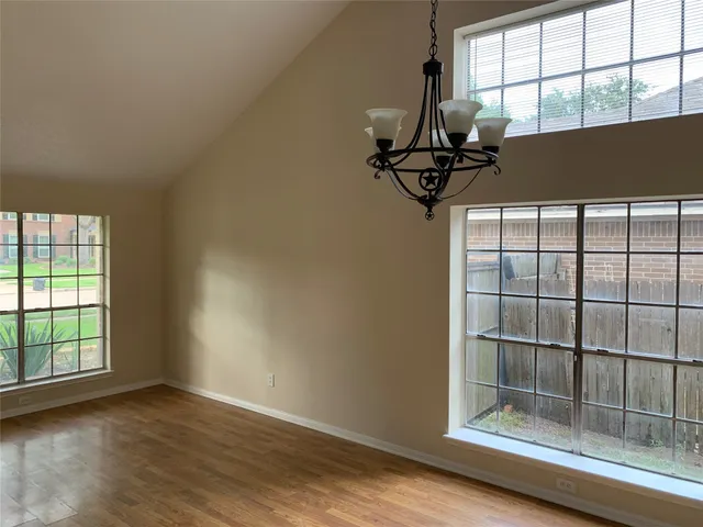 a view of a workspace room with wooden floor and windows
