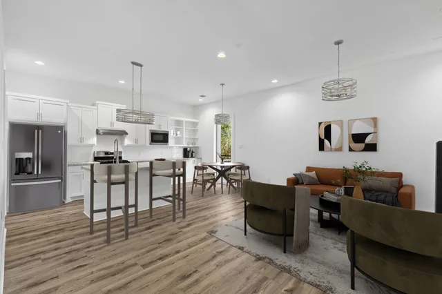 a living room with lots of furniture and kitchen view