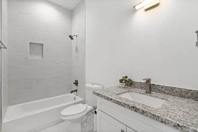 a kitchen with stainless steel appliances granite countertop a sink stove and microwave