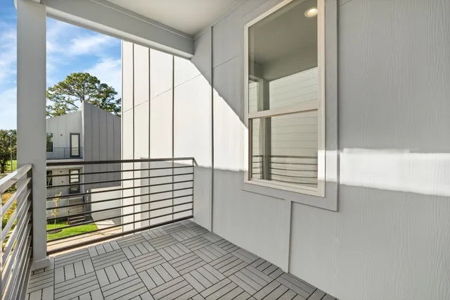 a view of a balcony with floor to ceiling windows with wooden floor