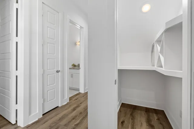 a view of an empty room with wooden floor and closet