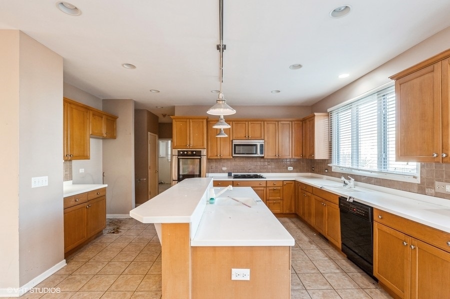 2021 Wright Boulevard Buffalo Grove, IL 60089 - Photo 11 of 29 a large kitchen with kitchen island a large counter space appliances and a window