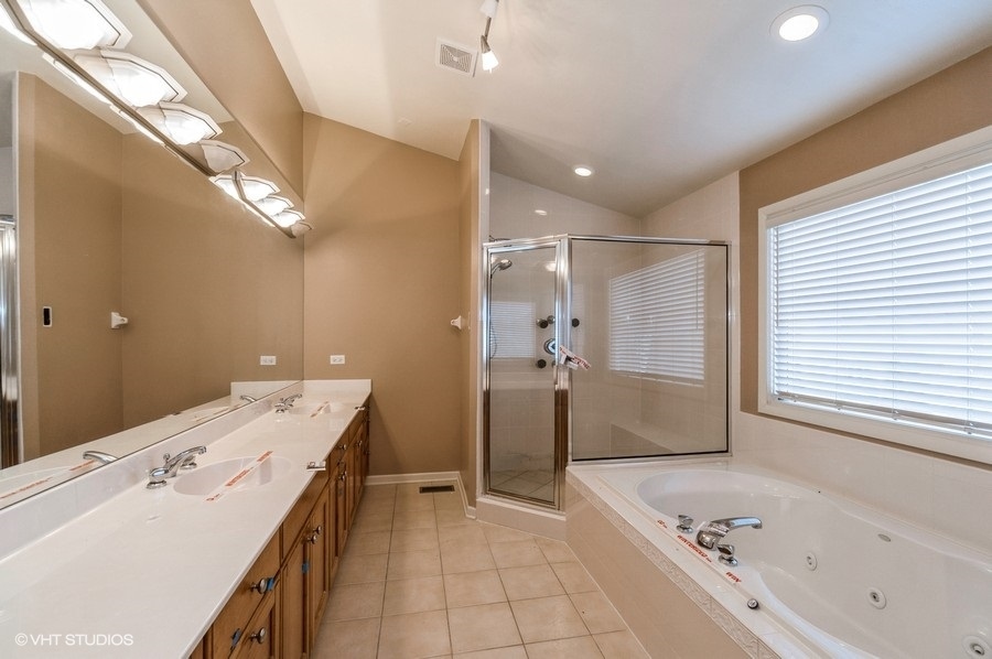 2021 Wright Boulevard Buffalo Grove, IL 60089 - Photo 18 of 29 a bathroom with a tub sink and a mirror