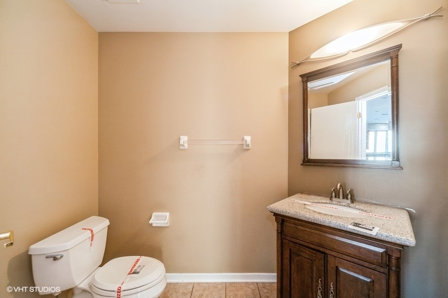2021 Wright Boulevard Buffalo Grove, IL 60089 - Photo 8 of 29 a bathroom with a sink a toilet and mirror