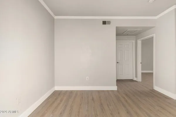 a view of an empty room with wooden floor