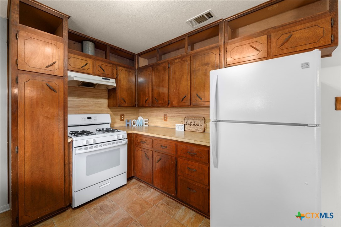 23168 Wolfridge Road Killeen, TX 76549 - Photo 15 of 42 a kitchen with stainless steel appliances a refrigerator sink and cabinets