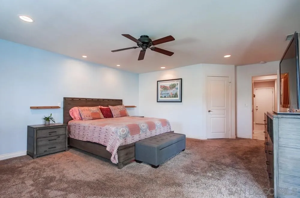 14020 Frame Road Poway, CA 92064 - Photo 16 of 52 a spacious bedroom with a bed and a chandelier