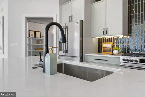 a kitchen with stainless steel appliances granite countertop a sink a stove and a wooden floors