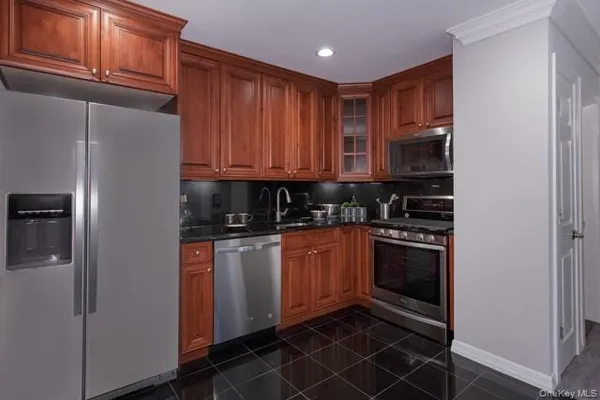a kitchen with stainless steel appliances granite countertop a refrigerator and a stove top oven