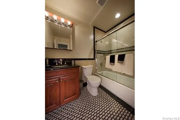 a bathroom with a sink a toilet and mirror