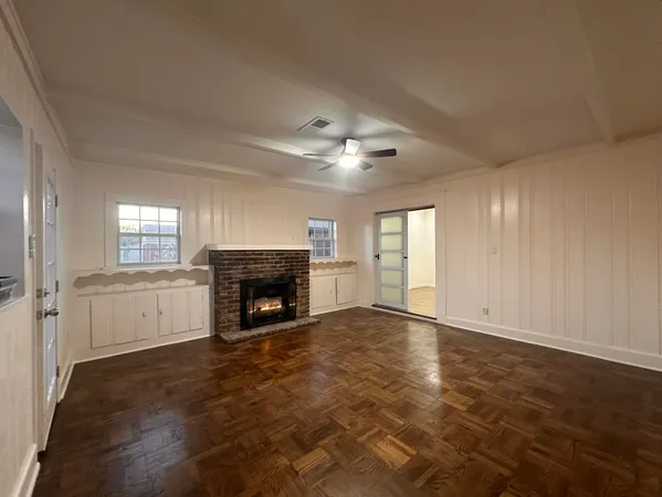 a view of an empty room with window and fire place