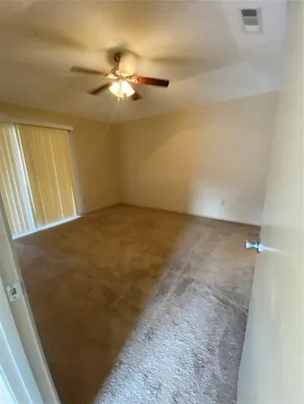 view of a big room with chandelier fan and windows