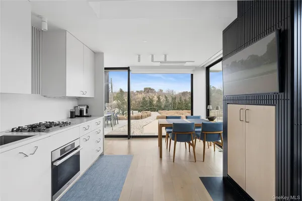 a open kitchen with granite countertop a stove top oven a sink a dining table and chairs