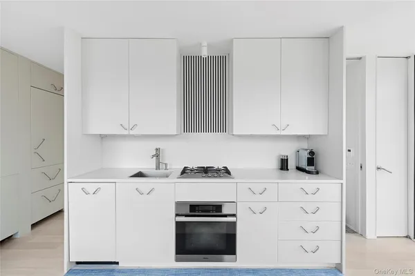 a kitchen with granite countertop white cabinets and stainless steel appliances